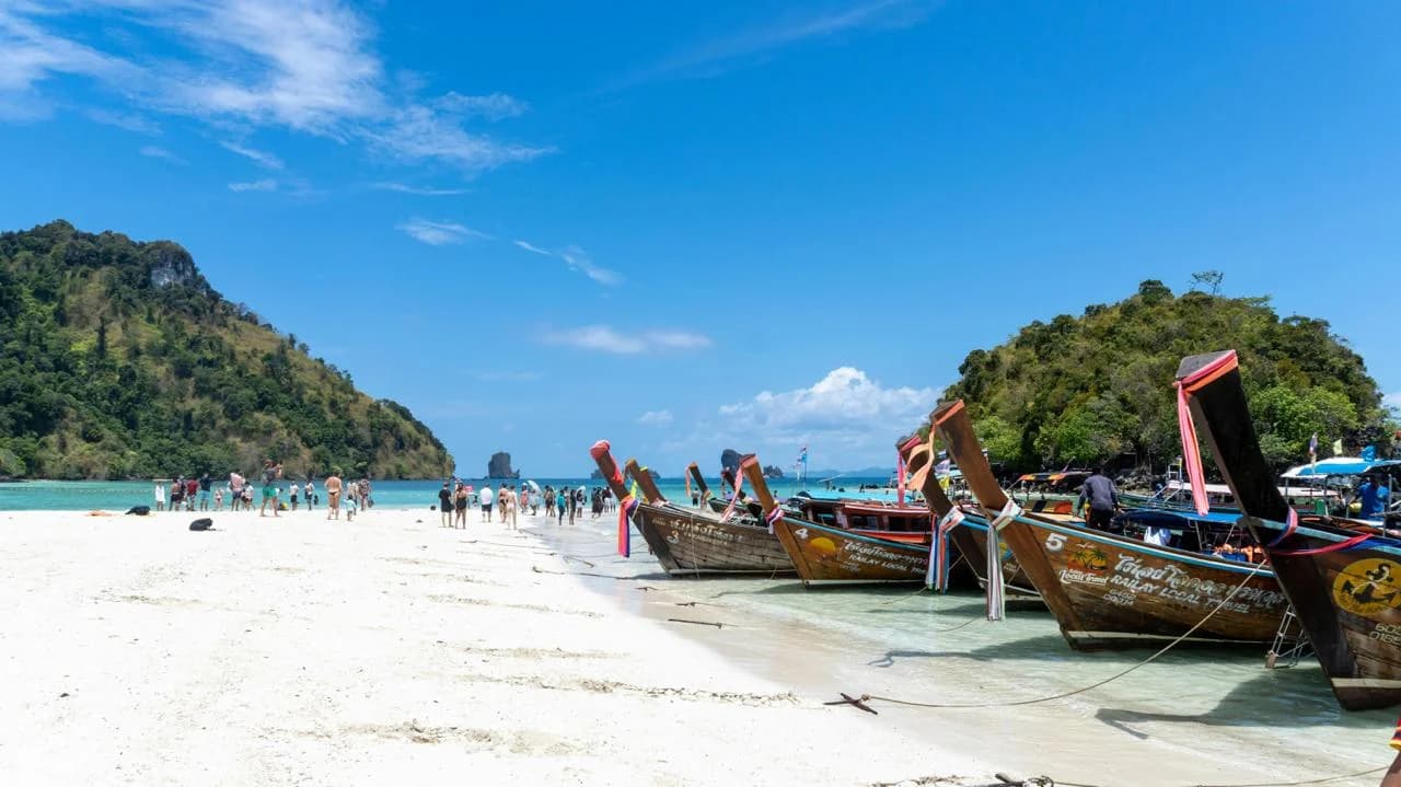 Longtail boats at Railay Beach in Phuket with limestone cliffs
